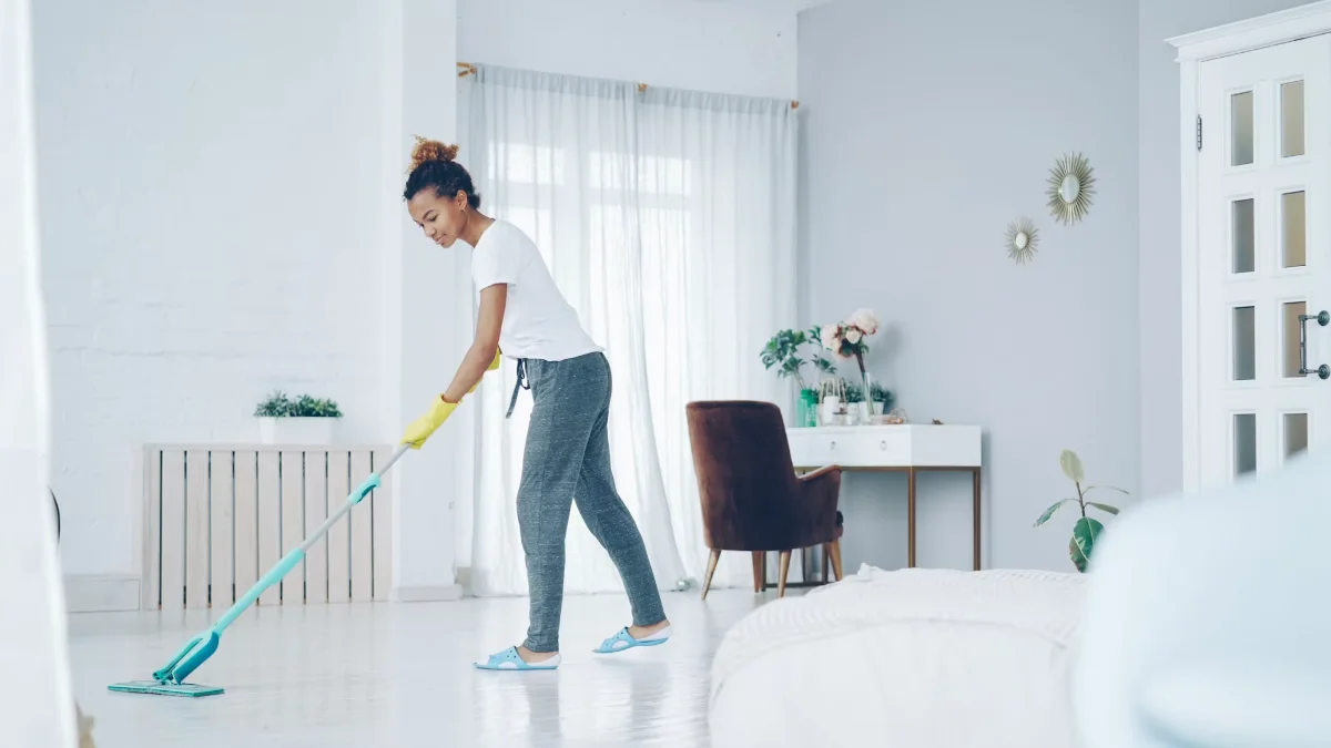 Nashville Pristine Clean technician mopping the floor of a bright, tidy bedroom